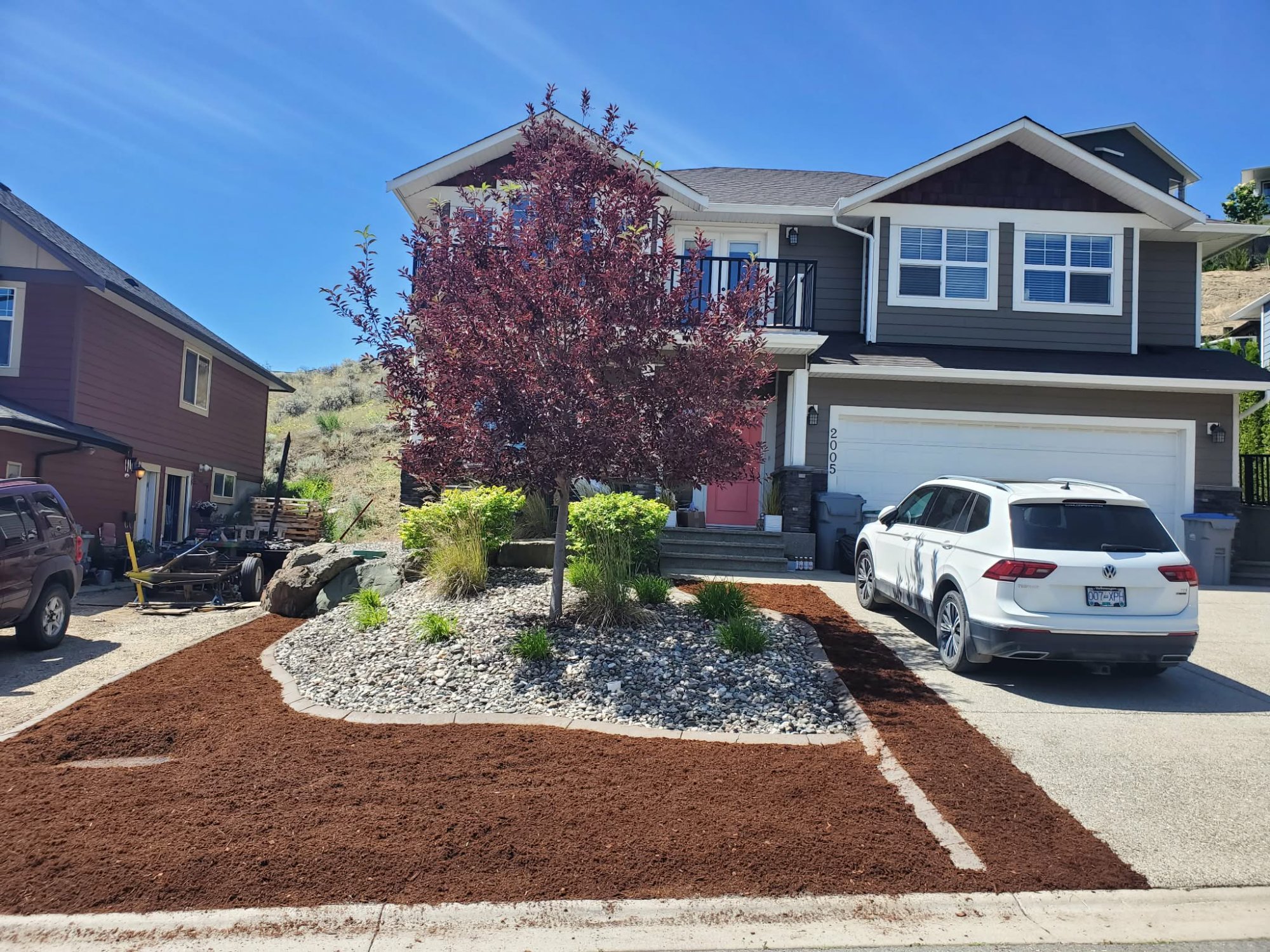 Beautifully designed residential front yard with ornamental tree and river rock